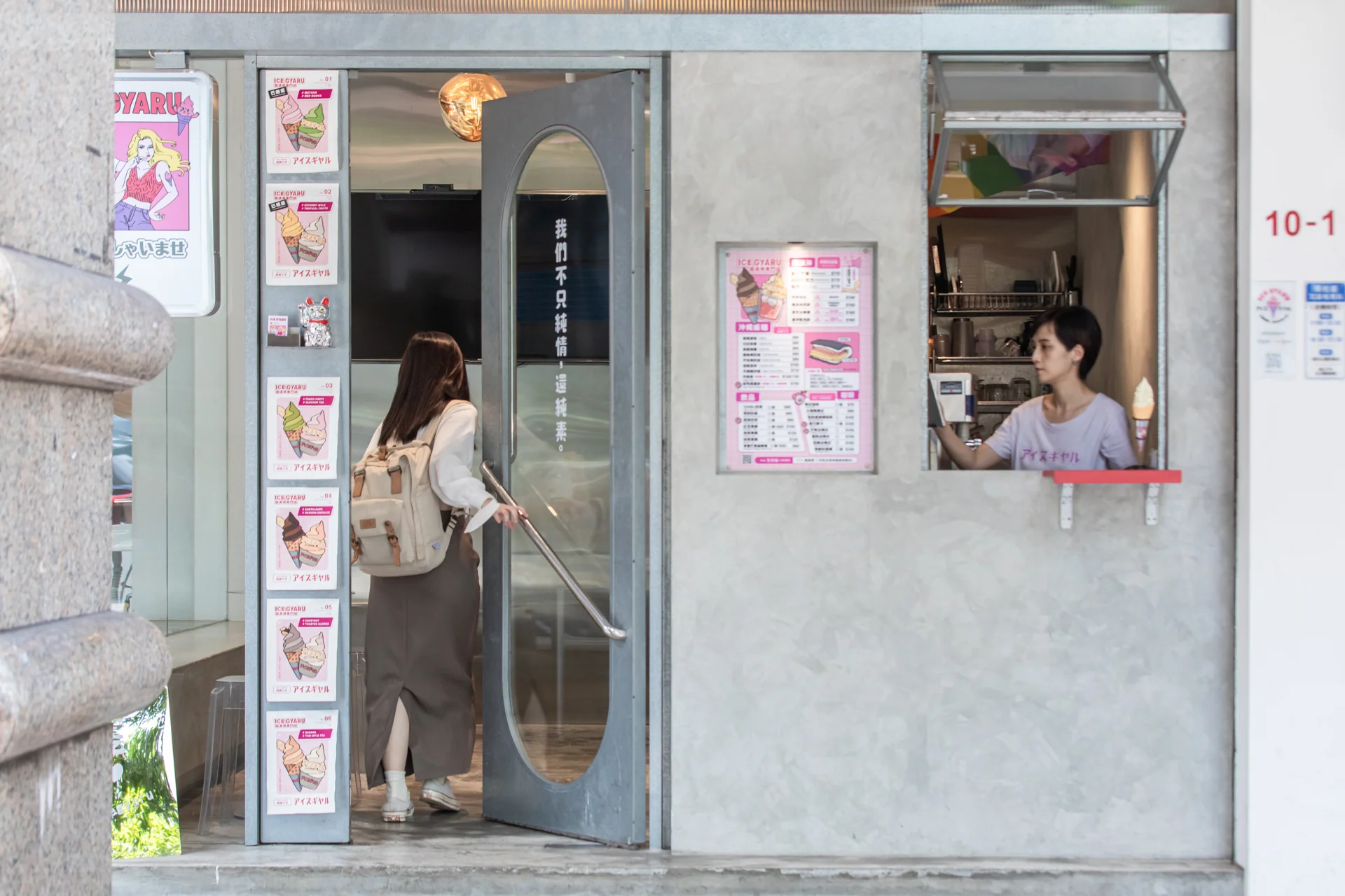一人推開店門進入 ICEGYARU，右側外送窗口站著 Erica。